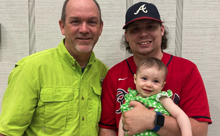 Todd London (left) stands next to his son Benjamin London (right), who is holding a very happy Baylor Kate.