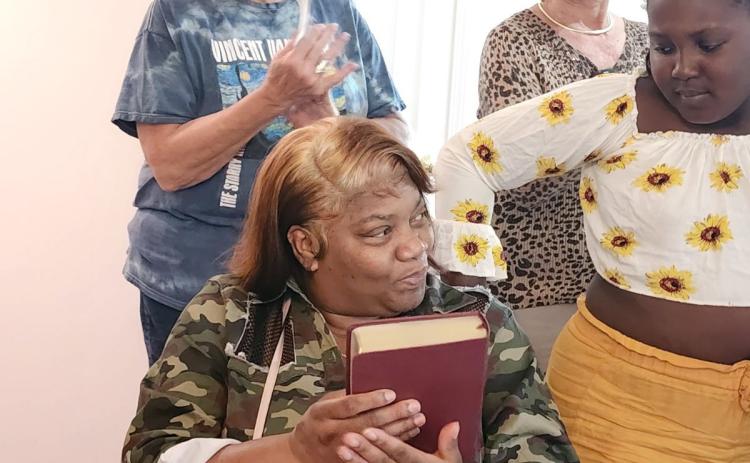 Above Yolanda Feaster has just received a new family Bible during the dedication ceremony in her new home.