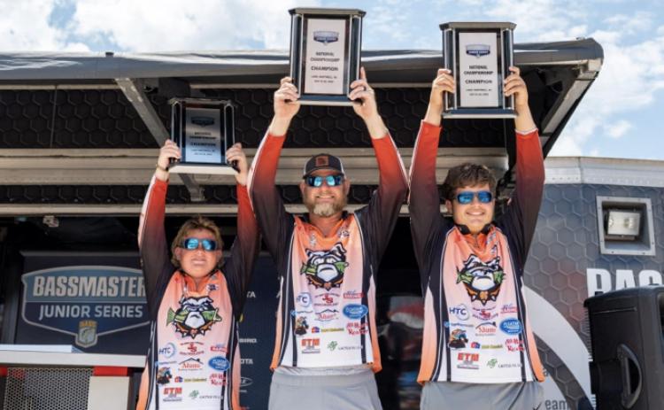 Pictured from left to right Kale Temple, boat captain Isaac Temple, and Luke Schnell hoisting up their Bassmaster Junior National Championship trophies during the awards ceremony on  Saturday, July 22 on Lake Hartwell. They also received a $2,000 scholarship during the ceremony as well. (Photo by Logan Crumley, Bassmaster)