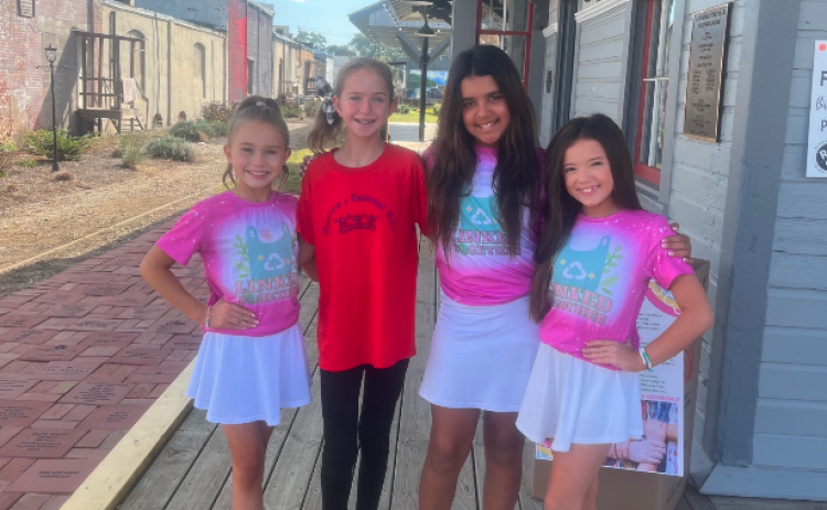 During their fall break from school, students (from left to right ) Haley, Andi Jane, Lila, and Sophie volunteer with Linked Together making mats for the homeless.