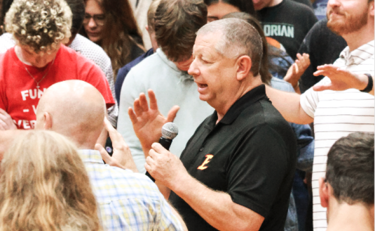 Emmanuel University President  Greg Hearn prays with his students.