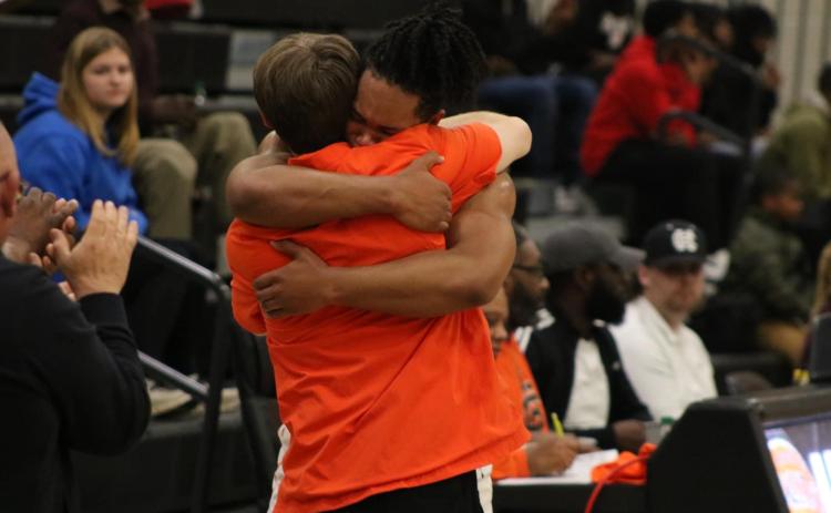 Senior forward Micah Reese hugs Dogs head coach Matt Gibbs as Reese checks out for the final time as a Bulldog. Photo by Grayson Williams/Hart County Charter System