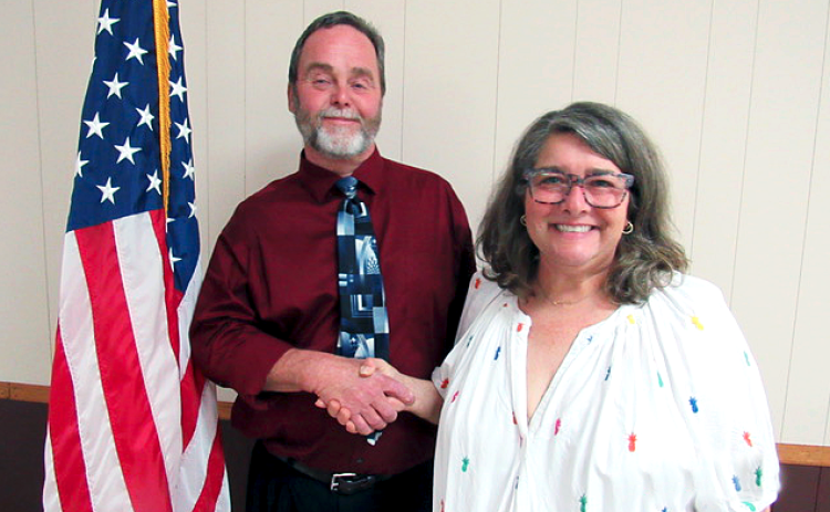 Bowersville Mayor John Smith shakes hands with Dee Schwarzmann after her first meeting on the city council.
