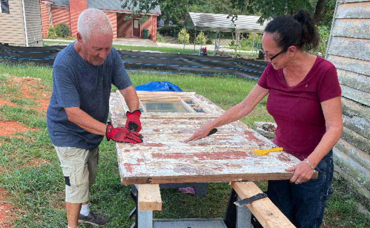 Lori Smith and her father, Richard, scraping paint off the front door from an E. Howell St. historic house last year.
