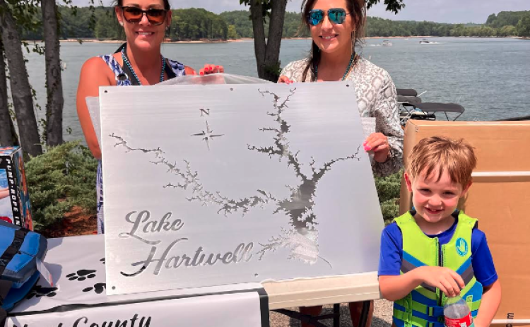 Joanie Haley (left) was declared the winner of the pontoon poker run. She won with a full house, and chose to take the metal map of Lake Hartwell. She posed for the picture with Laura Dickerson and her son Jordan Haley.