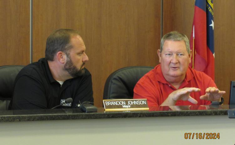 Hartwell mayor Brandon Johnson (left) and councilman Mike McNabb discuss T-SPLOST during a joint meeting June 16.