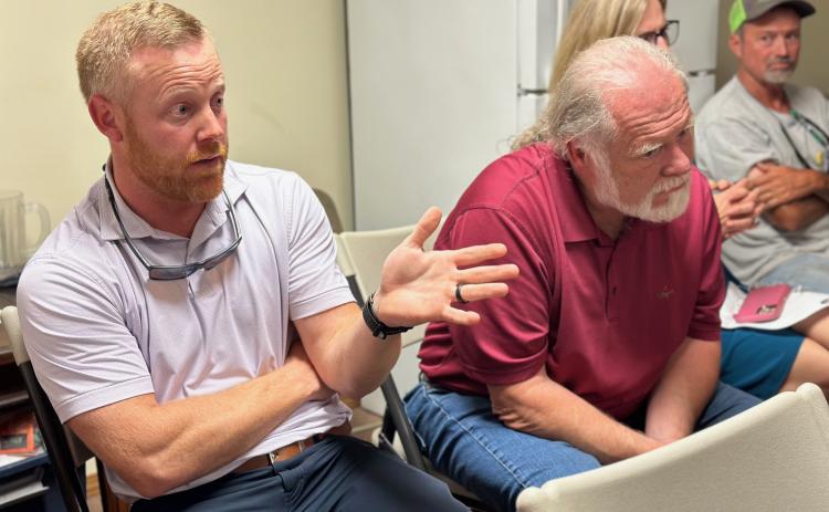 Commissioner Jeff Brown (left) speaks during the Bowersville Town Council meeting as Chairman Marshall Sayer listens in.