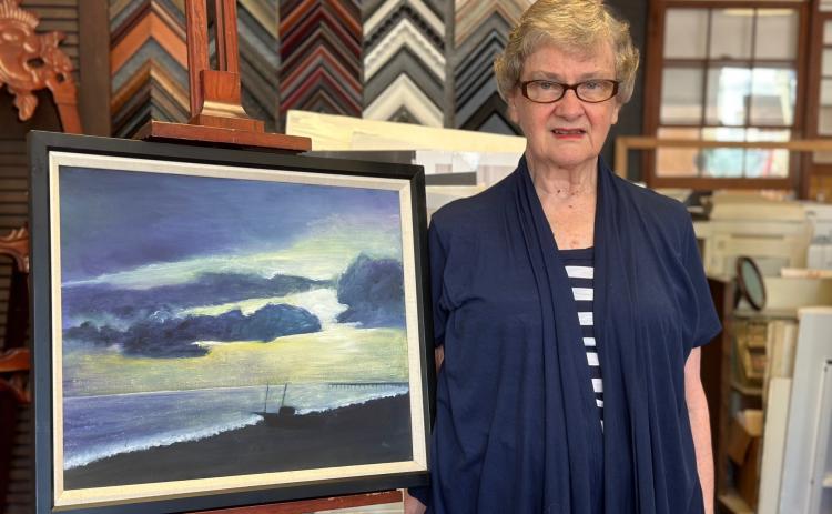 Louise Bisso with one of her paintings, inside ElsieBee Originals.