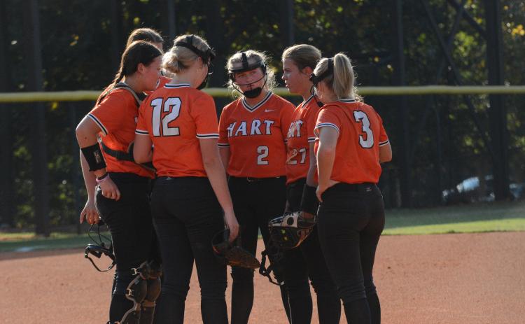 The Lady Dogs meet at the mound during a seven run second inning in the 15-0 run rule against the Lady Wolverines of Prince Avenue Christian on Sept. 24.
