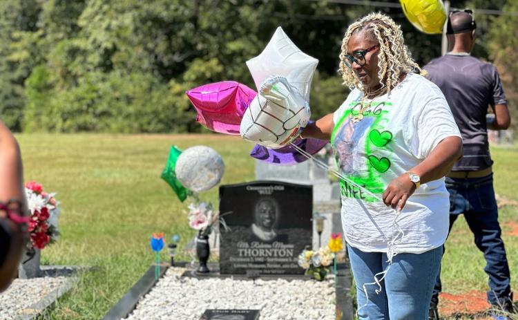 Crystal Thornton (left), the wife of the late Roberius Thornton who was shot and killed in an altercation at a local nightclub two years ago, hosted a balloon release at her husband’s grave site Sept. 2. Thornton is still searching for answers regarding her husband’s death, which remains and unsolved crime.