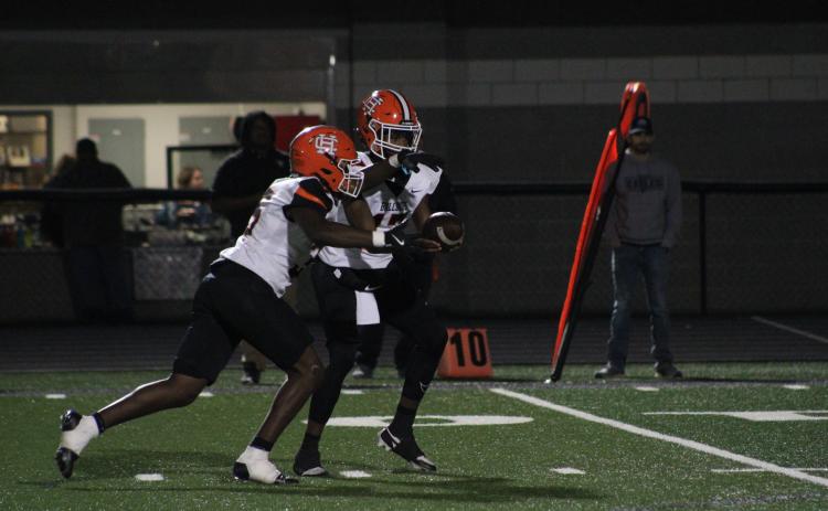 Sophomore quarterback Kurston Curry hands the ball off to sophomore running back Faustino Rangel, who scores three rushing touchdowns in the 40-10 win over the Eagles of East Jackson on Oct. 18. Photo by Cheyenne Tolleson/Jackson Harold TODAY