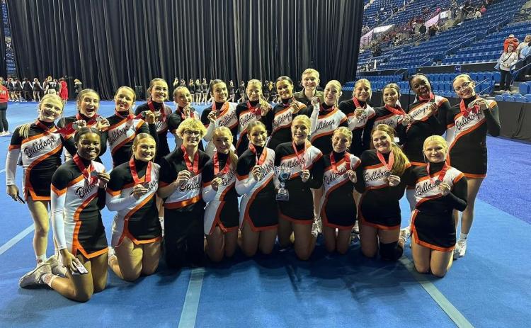 The Hart County High School sideline cheer squad flashes their medals and trophy after claiming state runner-ups at the GHSA gameday competition in Columbus, Ga. on Dec. 4.