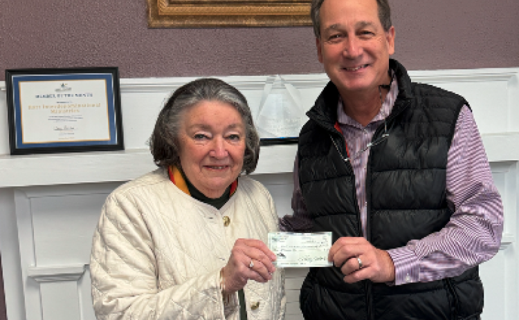 Christina Silpe (left) from Hart Interdenominational Ministries (HIM) receives a $2000 check from Lowell Macher, President of the Hart County Property Owners Association during their Holiday Harvest Fundraiser Nov. 23.