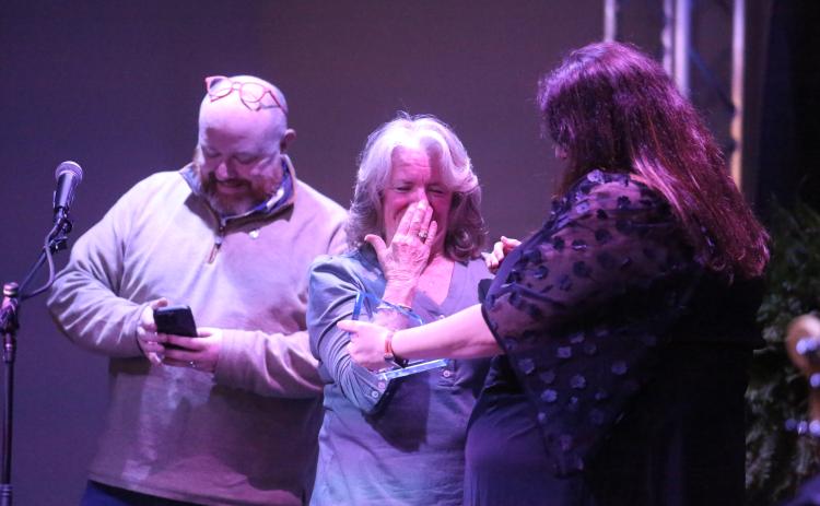 Debbie Kulcsar reacts to being named the Community Champion by Hart County Chamber of Commerce Executive Director Amanda Brown as Downtown Development Authority Director Jason Ford smiles in the background during the chamber’s annual awards banquet Feb. 21 at The Station of Hartwell.