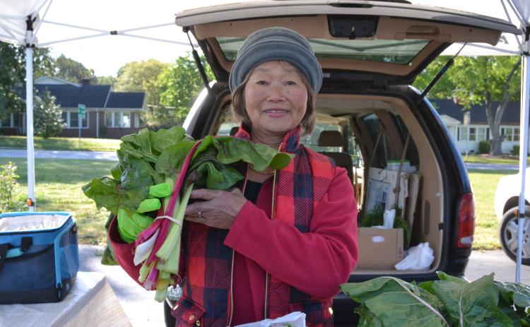 May Workman holds homegrown swiss chard during the opening weekend of the Hartwell Farmers Market April 12. Workman has been selling at the market for 22 years and sells berry plants, greens, carrots and other vegetables. (Photo/Adriana Cascio)