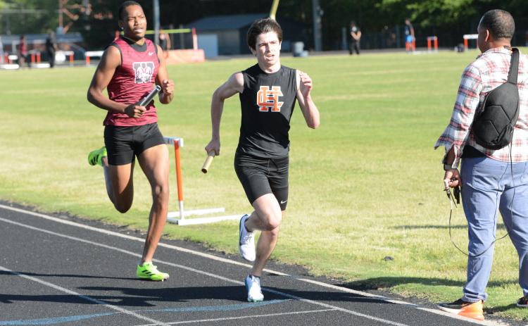 Sevyn Singleton (right) runs in the first leg of the 4x800-meter relay as he helped the Dogs place first in the event at the home meet against Westside on April 15. (Photo/Benjamin London)