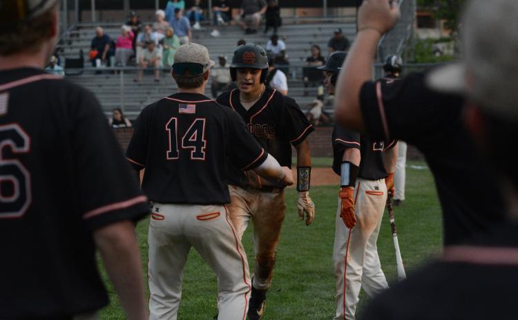 Senior catcher Pearce Mewborn (right) celebrates with freshman Slate Osborne (14) after scoring a run against Thomson in the first round of the state playoffs. (Photo/Benjamin London)