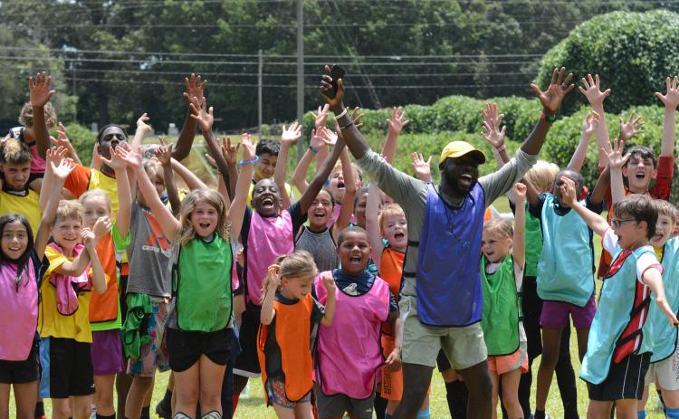 Pictured is YMCA’s sports director Kerv Augustin and kids during a soccer camp back in the summer of 2023. (Photo/Benjamin London)