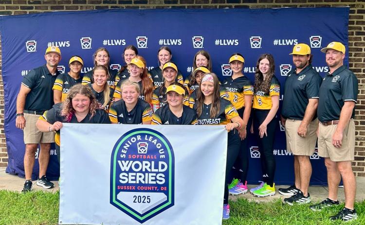 Hart County Senior League Softball team poses with a Senior League World Series banner before a game in the Senior League Softball World Series in Lower Sussex, Delaware. (Photo courtesy of Hart County Little League)