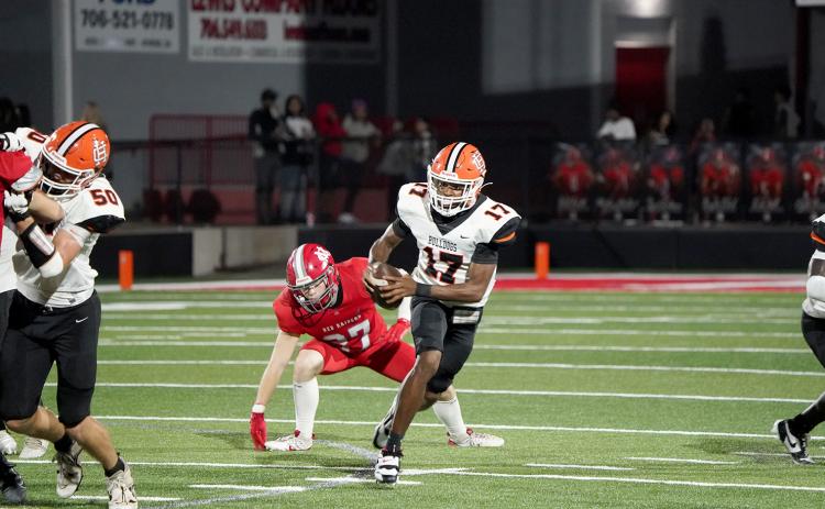 Junior quarterback Kurston Curry evades the pressure from the Red Raiders defense in the 28-14 loss to Madison County Aug. 22. (Photo by Ric Williams)