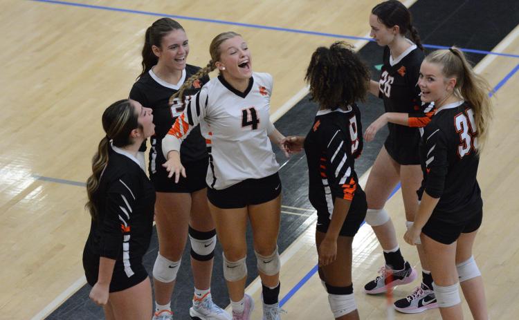 The Volley Dogs celebrate after picking up the 2-0 win (25-18 and 25-18) over the defending AAA state champion, the Lady Dragons of Jefferson Sept. 4. (Photo by Benjamin London)