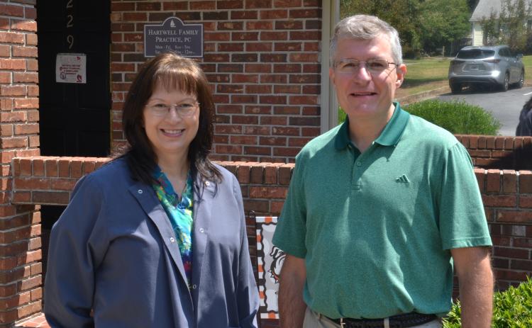 Nurse Lisa Walters (left) and Dr. JoDon Garringer (right) pose together in front of Hartwell Family Practice, located at 229 Athens St., on Sept. 3. Garringer said he and Walters have developed a brother-sister relationship, after watching their families and careers grow alongside each other. (Photo by Adriana Cascio)