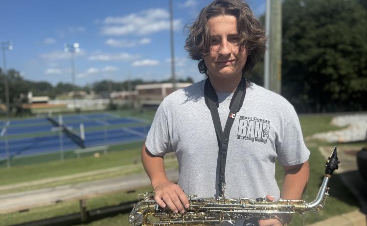 Sophomore saxophonist Henry Waters smiles and holds his instrument at attention after being named member of the week for this week’s High Notes series. Waters was not only recognized for his ability to stay in step, but also for always moving the band’s equipment. (Photo by Adriana Cascio)