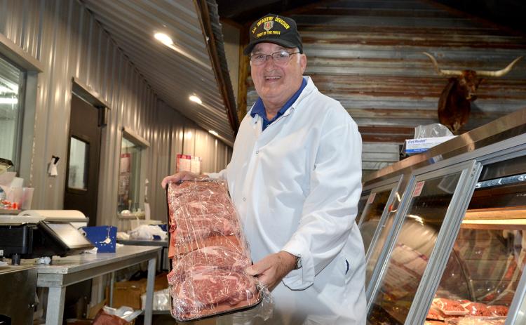 Winston Phillips, who has spent nearly six decades working in five different butcher shops, presents a tray of ribeyes, his favorite cut of meat, at Hometown Butcher.  (Photo by Adriana Cascio)