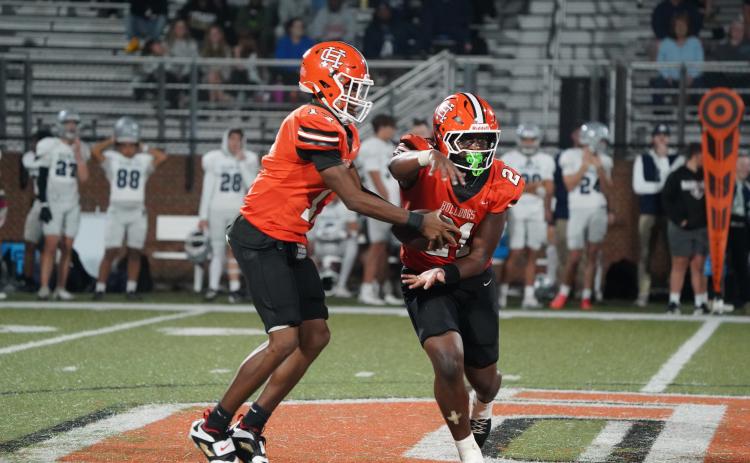 Junior quarterback Kurston Curry (left) fakes the hand off to his junior running back Faustino Rangel (right) before running a quarterback keeper in the 21-6 win over the Eagles of East Jackson Oct. 17. (Photo by Ric Williams)