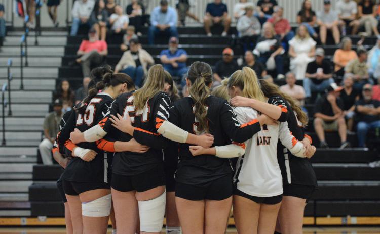 The Volley Dogs huddle up to pray before a match earlier in the season against A.R. Johnson of Augusta Oct. 14. (Photo by Benjamin London)