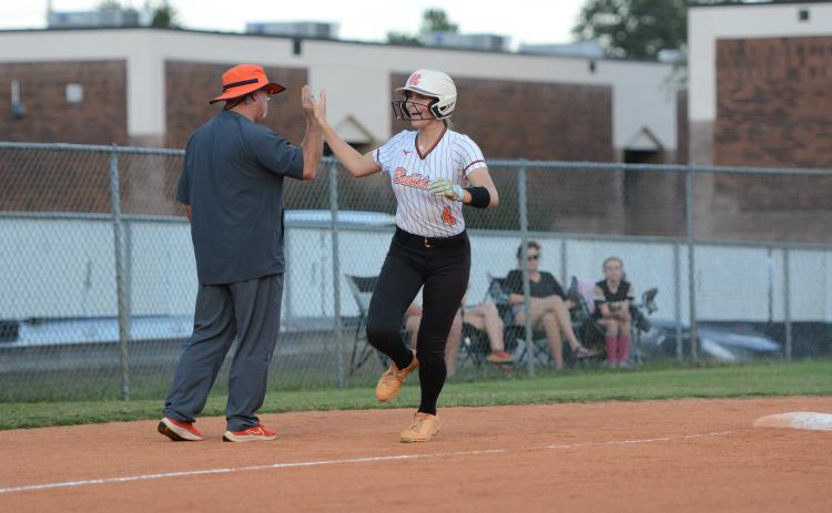 Senior infielder Madi Bennett rounds third and high fives Lady Dogs head coach Gerald Gates after hitting a solo home run en route to a 7-4 win over the Lady Tigers of Commerce Oct. 8. (Photo by Benjamin London)