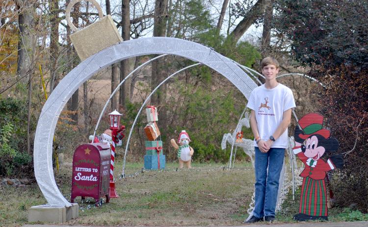 Hart County High School 11th grader Tyler Bowers stands in front of the entrance to his light display on Cedar Creek Circle. The display celebrates a decade of bringing Christmas cheer to the community.