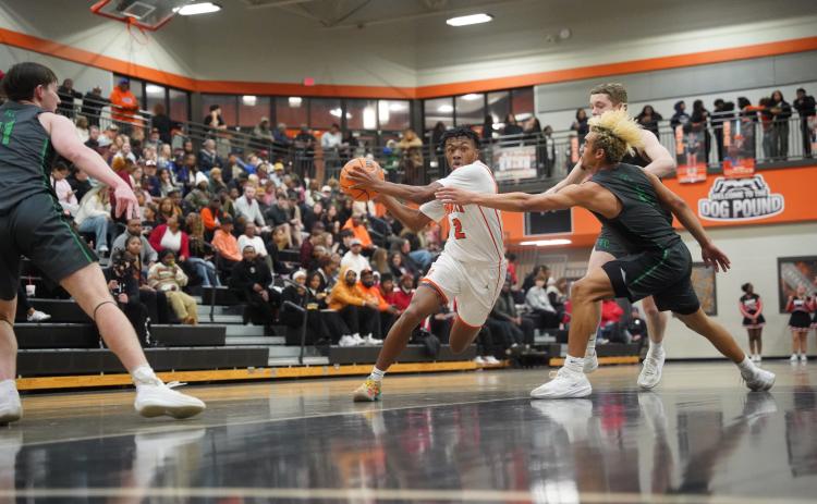 Senior guard Zaylen Shealer (left) drives to the basket against two Lion defenders, as he scores a career high 32 points in the 89-61 win over Franklin County Jan. 20. Photo by Ric Williams.