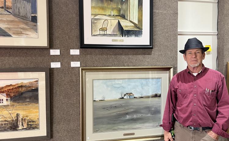 Stan O’Bannon stands next to his works at the Hartwell Art Center. His exhibit will kick off with an opening reception tonight and will be open through March 21. Photo by Madison Linton.