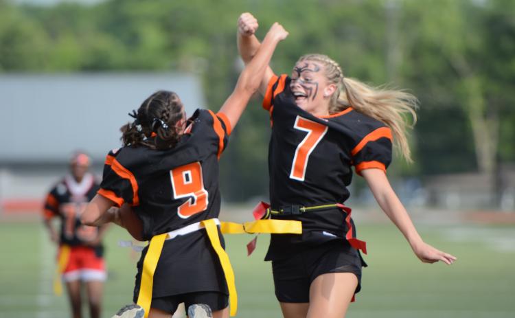 Seniors Hannah Jo Coker (left) and Erin Miller (right) celebrate after Coker’s second rushing touchdown in the 12-6 win over the Juniors in the annual Powderpuff game May 22. Photo by Benjamin London. 