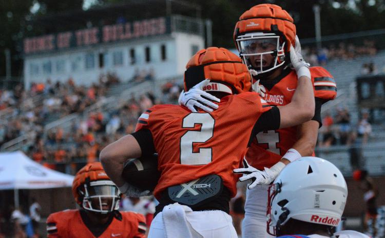 Senior wide receiver Knox Pierce (2) celebrates with teammates Crew Franklin (right) and Kurt Curry (left) after scoring the opening touchdown of the game in the 49-0 win Aug. 7.  Photo by Benjamin London. 