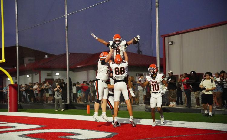 Offensive players celebrate with senior running back Kaidyn Allen (8) after scoring from 14 yards out, as the Dogs advanced to 2-0 with a 51-12 win over the Red Raiders of Madison County Aug. 28. Photo by Ric Williams. 