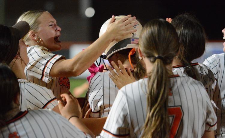 Senior infielder MaryBeth White gets mobbed by her teammates as she walked it off with an RBI single to run-rule the Lady Devils of Elbert County in six innings, 8-0, Sept. 17. Photo by Benjamin London.