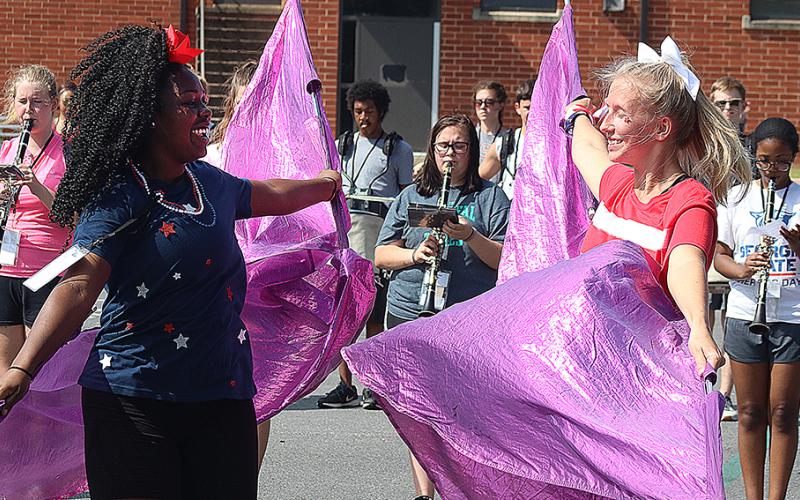 Flag corps members Detricunna Teasley, left, and Samantha Campbell, right, practice their flag routine during Hart County High School band camp on Monday. 