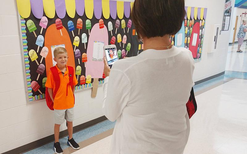 Second-grader Trooper Ayers gets his picture taken on the first day of school at South Hart Elementary on Aug. 1 by his mother Heather Ayers. 