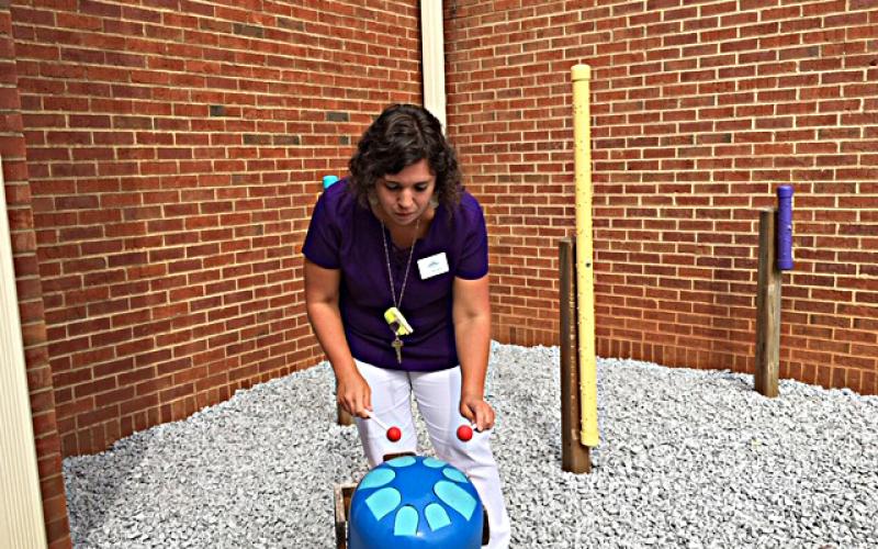 Photo submitted by Anna Hall — North Hart Elementary School music teacher Holly Fredericks plays her favorite addition to the school’s recently completed sound garden: a propane tank painted blue has been turned into a tank drum. 