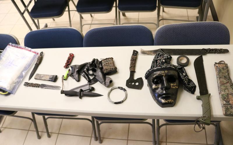 A bag of methamphetamine, at left, allegedly taken from a Hart County man, and knives, a hatchet, machetes, a mask and other items, allegedly taken from people out to kidnap and kill the man, are shown.