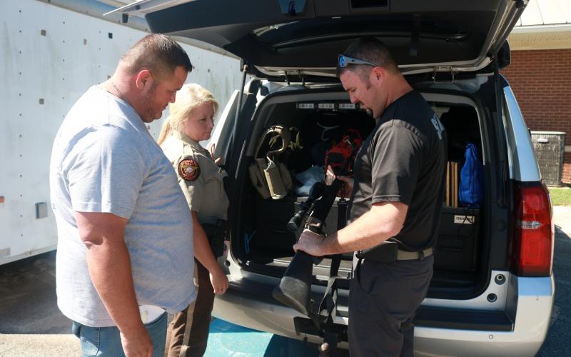 Sunshot by Grayson Williams -- Hart County Sheriff's Office investigators Kevin White, Kristi Hughes and Chris Carroll look at equipment recently at the Sheriff's office.