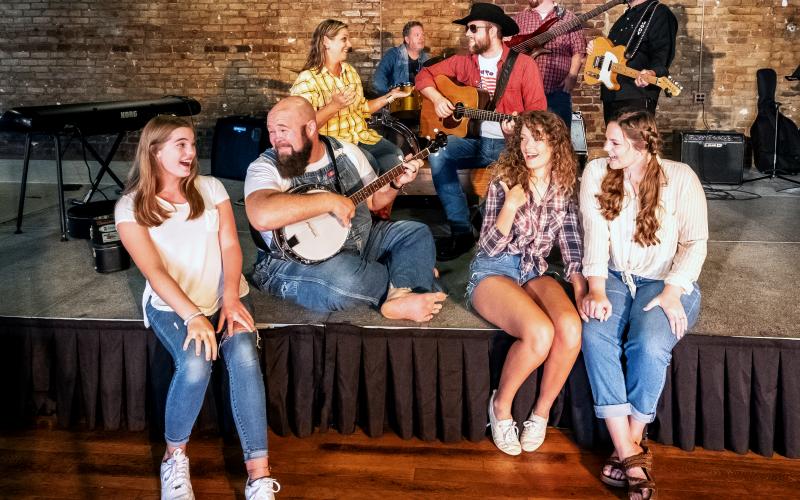 Sunshot by Bill Powell Pictured are Nash McCan and the McCan Family Band. Front row: Ella Long, Seth Howard, Victoria Evans amd Olivia Berry. Second row:  Andrea Bradford and Nash McCan (Josh Bryan). Back Row:  Kevin Long, Casey Middlebrooks and Jody DiMarco. Not Pictured: David Phillips and Jamee Floyd.