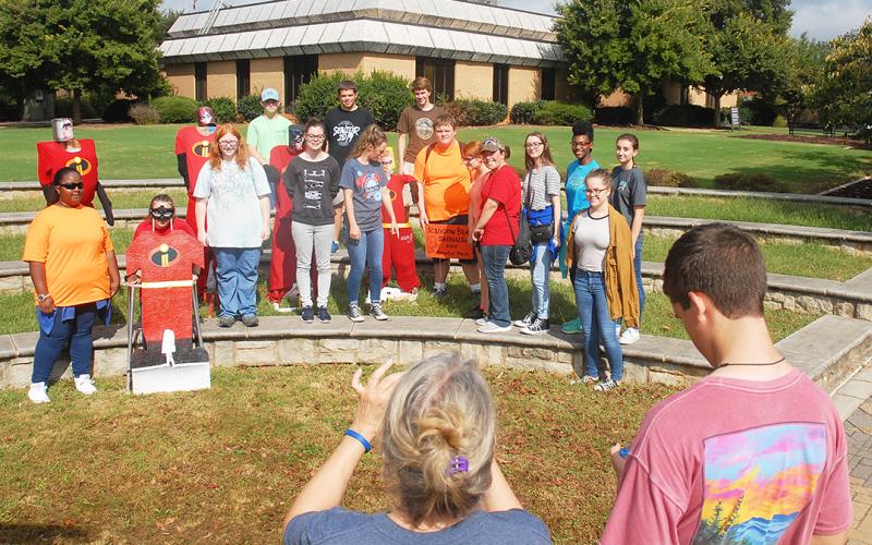 Vicky Carter, center, takes a photo of SkillsUSA students in October 2018 after they put up their “Incredibles”-themed scarecrows for last year’s Scarecrow Bash.