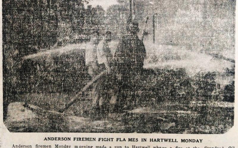 In this faded image on newsprint, Anderson firefighters fight a fire in Hartwell at the Standard Oil Company in 1944. 