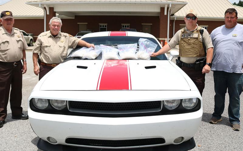 File photo -- Sheriff Mike Cleveland and deputies pose in June by the Dodge Challenger and the nearly 11 pounds of methamphetamine seized in a traffic stop on I-85. The driver of the car was indicted recently by a Hart County grand jury.