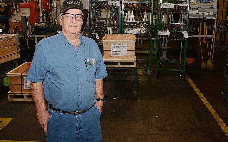 Sunshot by Michael Hall — George Adams poses for a photo in the factory at Tenneco where he has worked since 1959. He will retire when the plant closes later this year. 