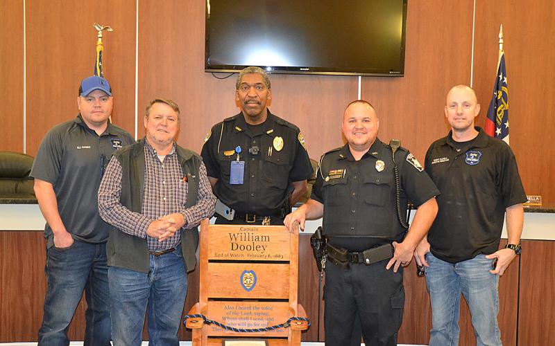 Sunshot by Drew Dotson — Eli Gomez, from left, Hart County Commissioner Ricky Carter, Hartwell Police Chief Anthony Davis, Royston police officer Rick Carter and Tony Capell pose for a photo with a chair donated by Gomez and Capell’s nonprofit, Saving a Hero’s Place.