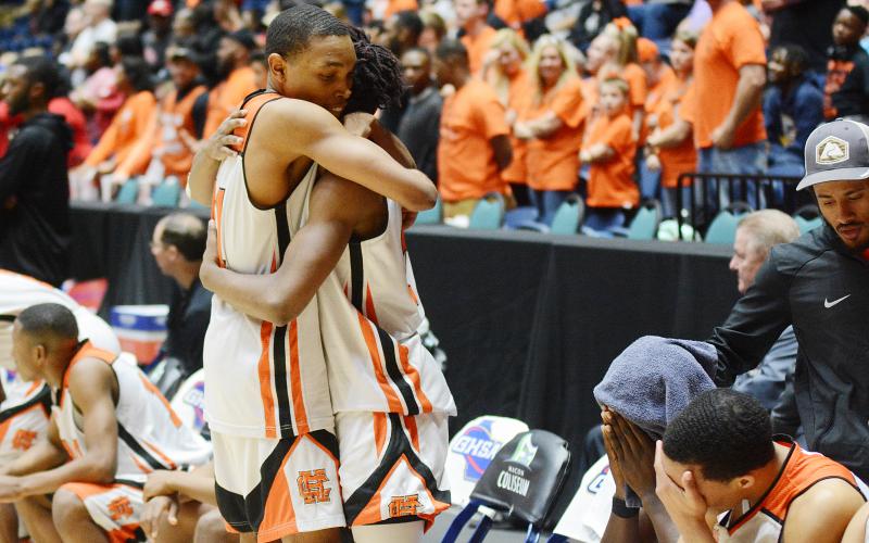 Sunshot from file — Hart County sophomore Shone Webb, left, consoles teammate, senior Elijah Robinson as time ticks down in the Bulldogs’ state championship loss in March in Macon as other teammates sit on the bench with heads in hands.